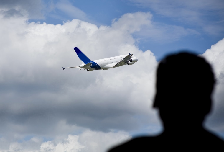 Image: A man watches a plane take off