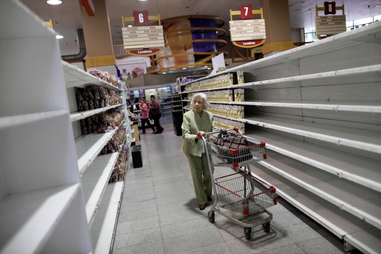 Image: People buy food and other staple goods inside a supermarket in Caracas