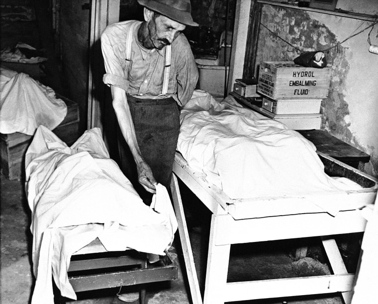 A coroner places a sheet over the body of one of the victims of the Moore's Ford lynching on July 27, 1946. 