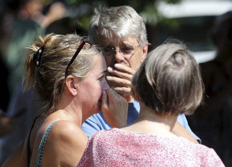 Image: Former Minnehaha Academy employees Elizabeth Van Pilsum, left, and Rick Olson, center, react after an explosion at the schoo
