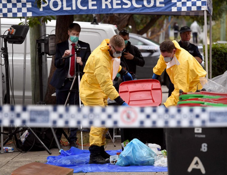 Image: Police search for evidence at a block of apartment 