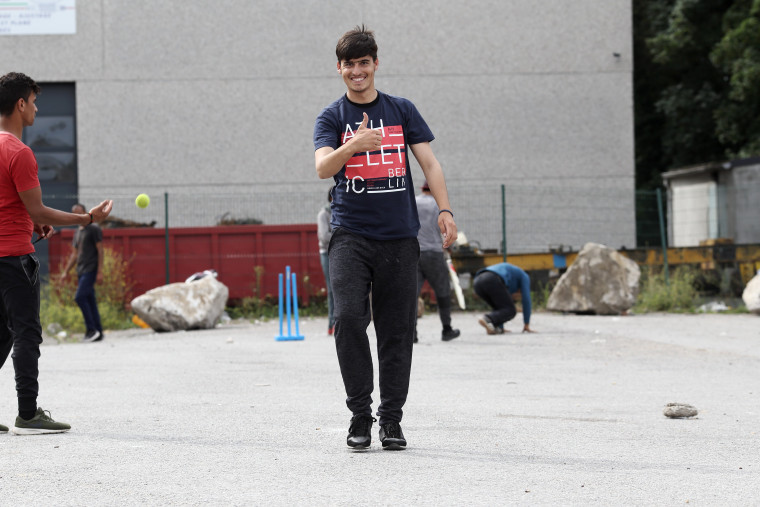 Image: Rehan Barakzai, 16, plays cricket in Calais with other Afghan migrants.