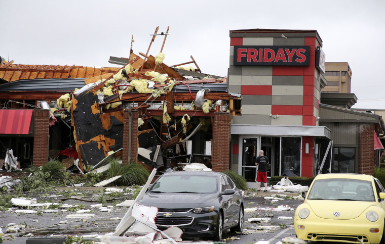 Image: A man stands outside a Fridays restaurant after a storm moved through the area in Tulsa, Oklahoma, Aug. 6, 2017. A possible tornado struck near midtown Tulsa and causing power outages and roof damage to businesses.