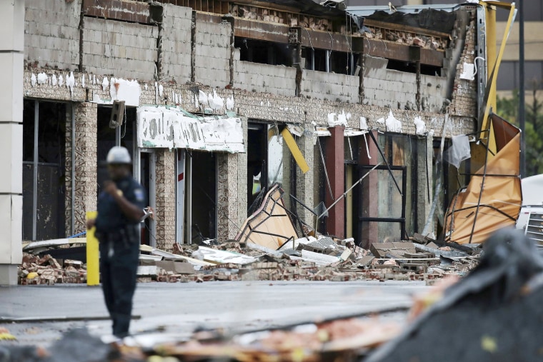 Image: A man stands near a damaged building after a storm moved through the area in Tulsa, Oklahoma Aug. 6, 2017. A possible tornado struck near midtown Tulsa and causing power outages and roof damage to businesses.