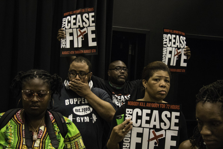 Image: Participants are solemn immediately after the 211 names are read, Aug. 6, 2017. At a downtown vigil to close out the Baltimore Ceasefire, people gather to remember the 211 victims of gun violence that Baltimore has seen already in 2017.