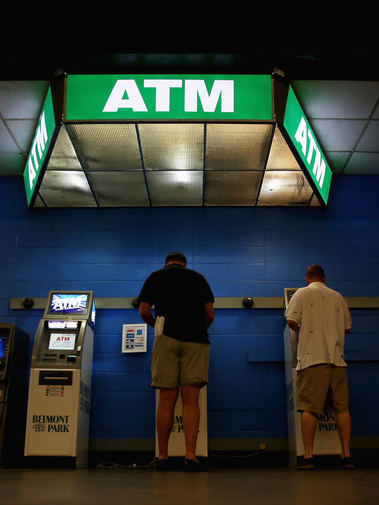 Image: People withdraw money at ATMs