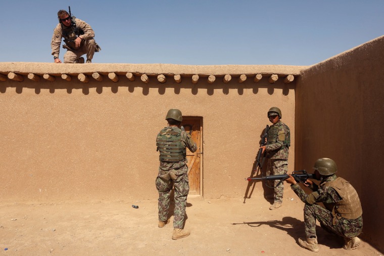 Image: A U.S. Marine, left, watches Afghan National Army (ANA) soldiers during training in Helmand province