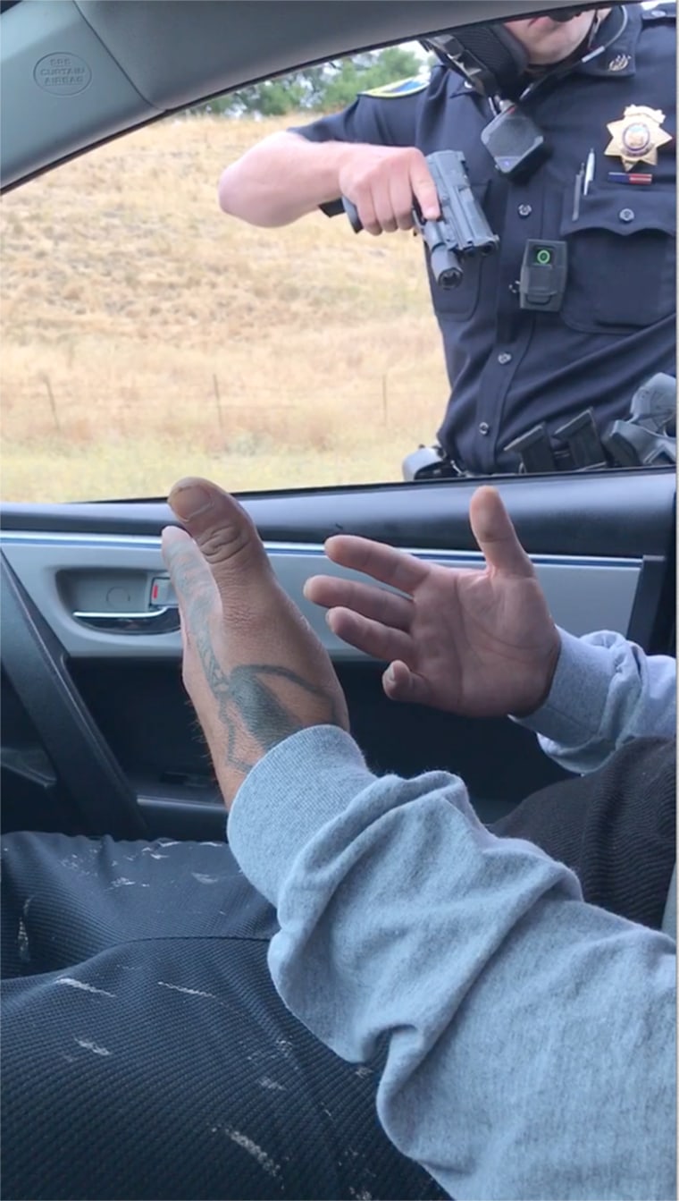 Image: A cop points a gun at a passenger on on Highway 101.