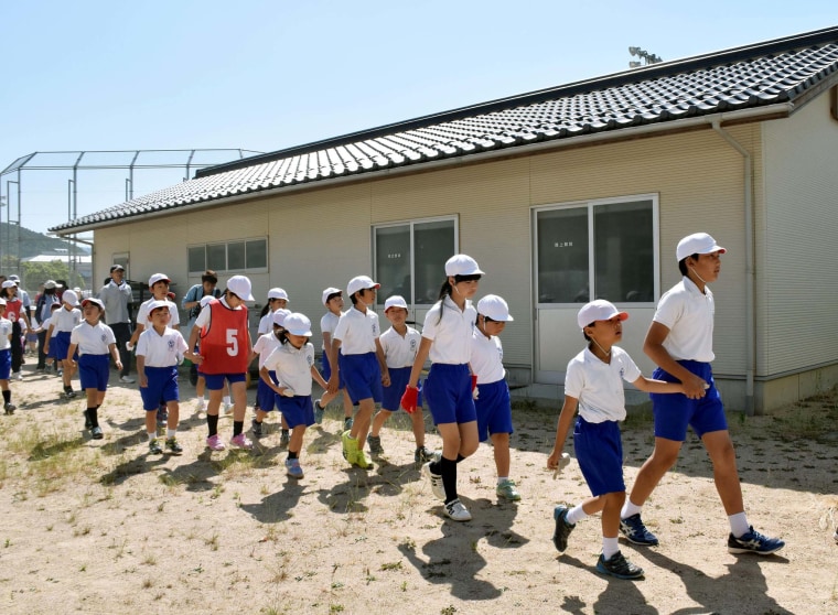 Image: Schoolchildren leave the compound of their school during an evacuation drill 