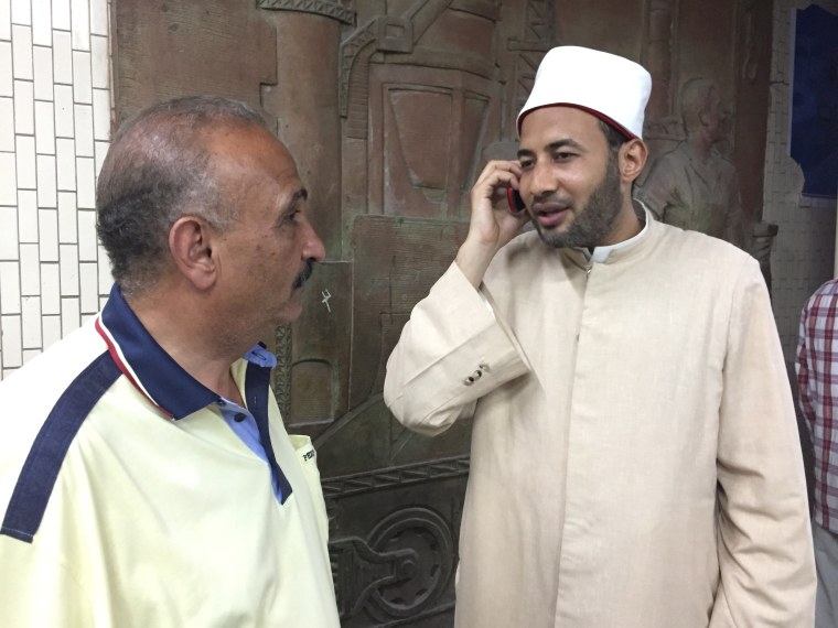 Image: Sheikh Ali Mostafa (R) offers advice about family matters to the wife of Gamal Al Din (L) in the subway station.