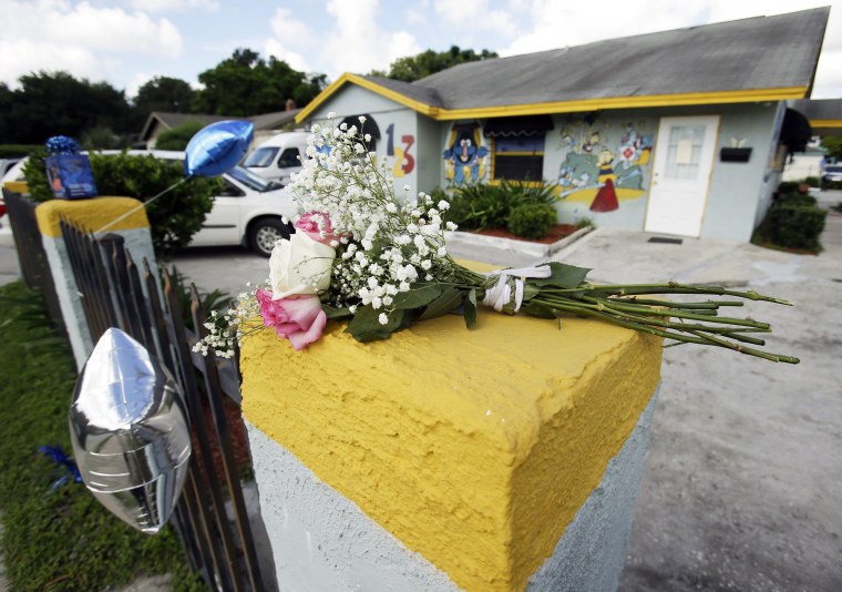 Image: Flowers and balloons are left outside at a makeshift memorial