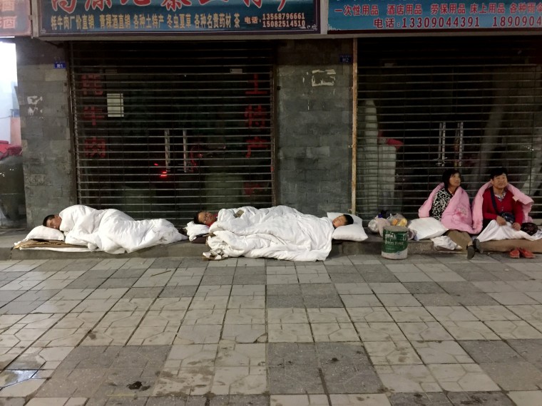 Image: Tourists Sleep on a Street After an Earthquake in Jiuzhaigou County