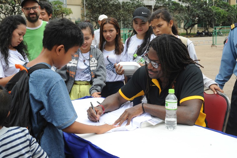 Neftalie Williams signing autographs in Cambodia.