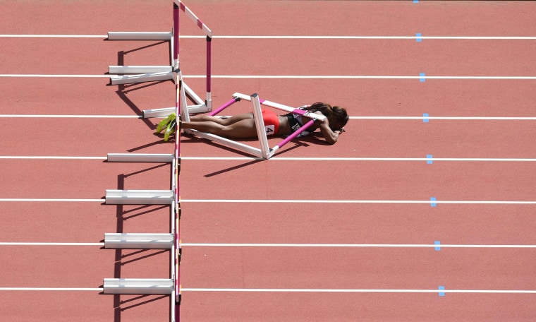 Image: Deborah John lies on the track after falling in the women's 100m hurdles athletics event