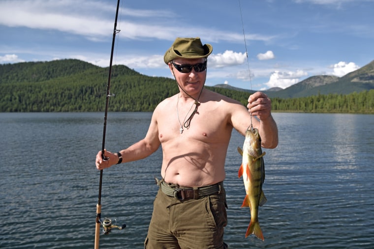 Image: Putin holds a fish he caught during a mini-break in the Siberian Tyva region