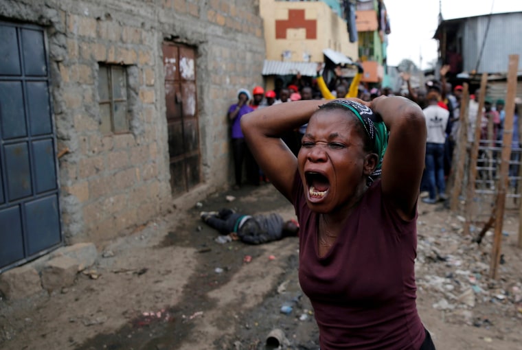 Image: A woman gestures as she mourns the death of a protester in Mathare, in Nairobi