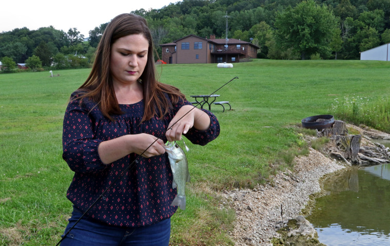 Image: Abby Finkenauer prepares to release a small bass she caught from her family's back yard pond in Sherrill, Iowa near Dubuque, Aug. 10, 2017.