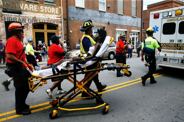 Image: Rescue workers transport a victim who was injured when a car drove through a group of counter protestors at the "Unite the Right" rally Charlottesville