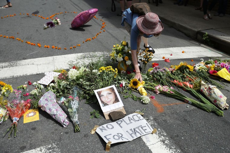 Image: A woman places flowers at an informal memorial to 32-year-old Heather Heyer