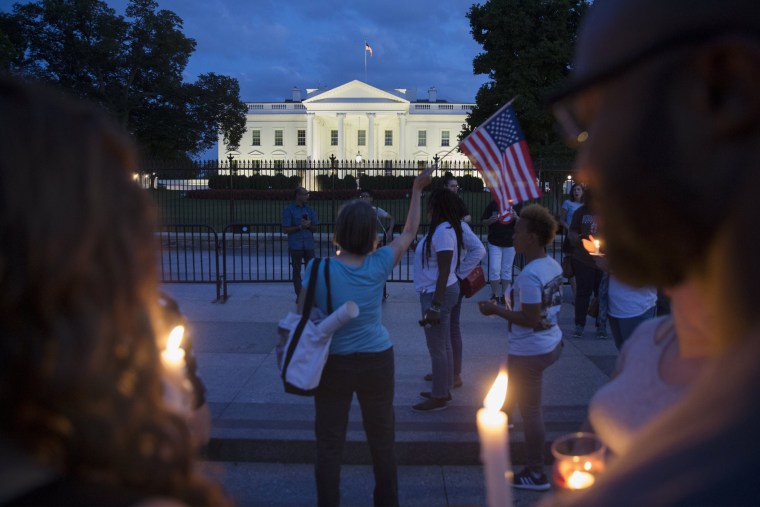 Image: People participate in a candlelight vigil at the White House