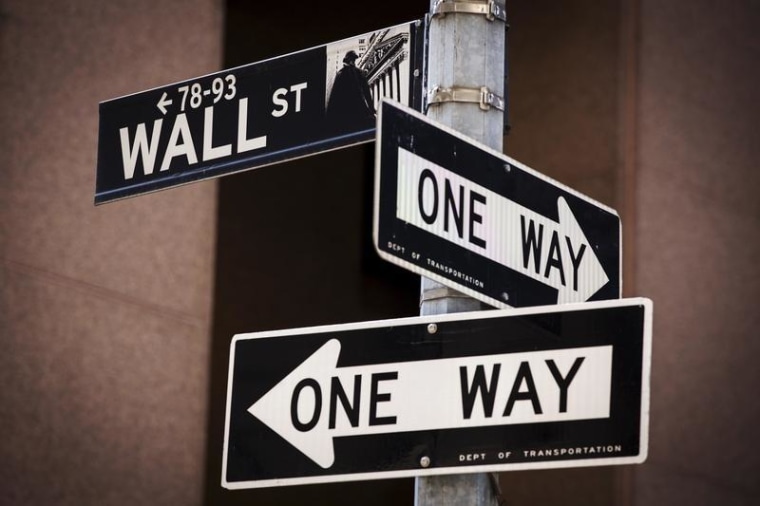 A 'Wall St' sign is seen above two 'One Way' signs in New York