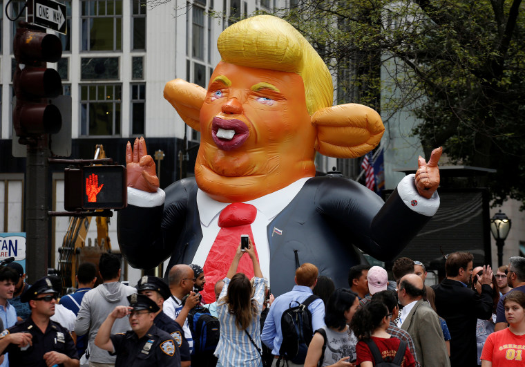Image: People looks at a giant inflatable rat in the likeness of U.S. President Donald Trump, displayed near Trump Tower in New York
