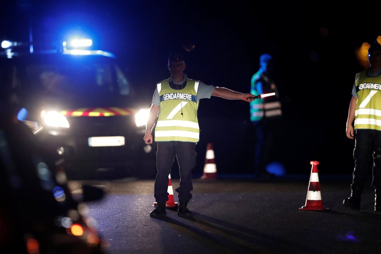 Image: French gendarmes maintain a roadblock a certain distance from the scene where a car ploughed into the outdoor terrace of a pizzeria in Sept-Sorts