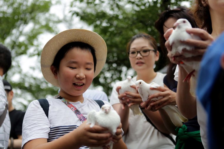 Image: Attendees hold doves, the symbol of peace