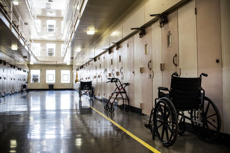 Image: Wheel chairs and walkers sit outside prison cells at California Medical Facility