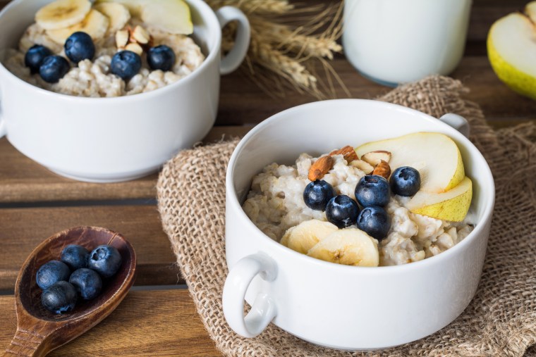 Image: Two bowls of oatmeal with pear, blueberries, almonds and honey