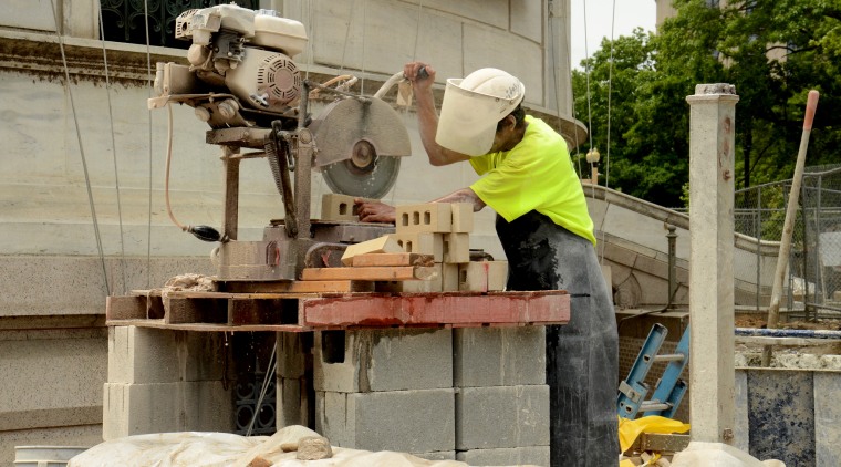 A construction worker cuts brick in Washington, D.C.