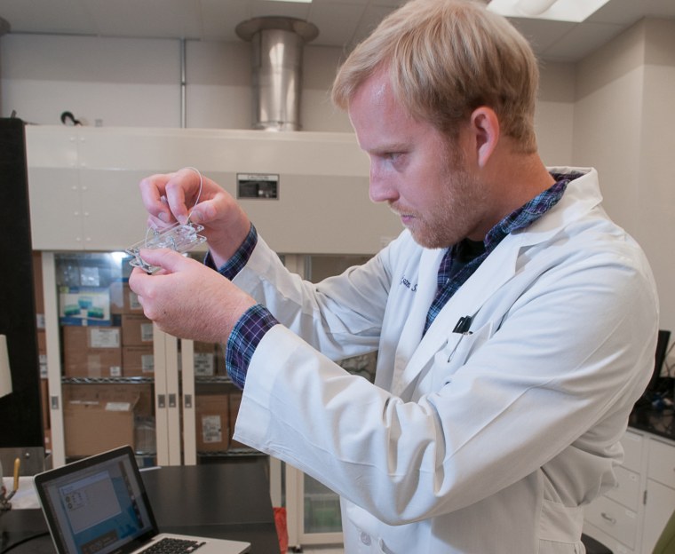 Dr. Aleksander Skardl demonstrates a "body-on-a-chip," a method of testing cell reaction to toxins, in a lab at Wake Forest Institute for Regenerative Medicine.