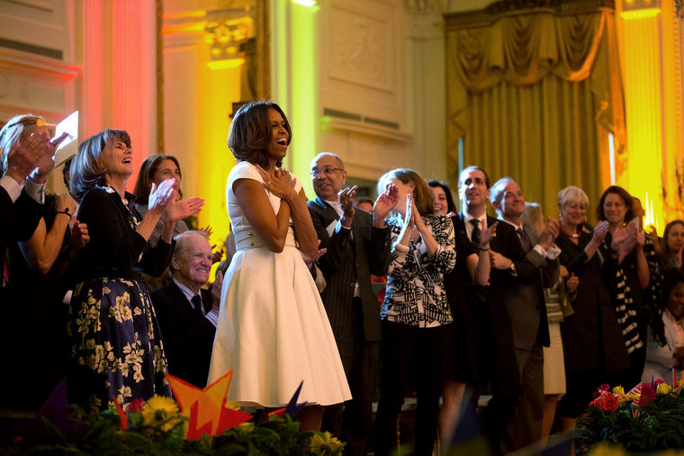 First lady Michelle Obama show her appreciation during the White House Talent Show in 2014 hosted by the President's Committee on the Arts and the Humanities.