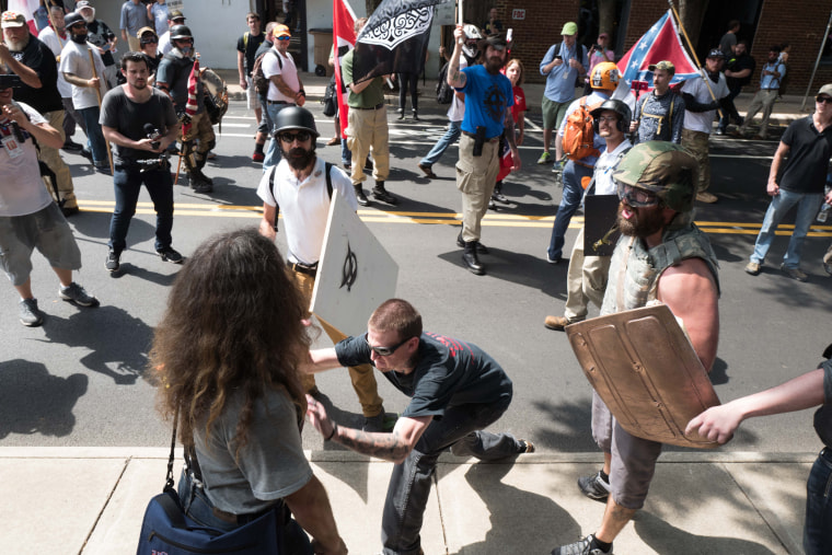 Image: A neo-Nazi man rips a sign out of a protester's hand and snaps it in half on his knee before throwing it on the floor and walking off.