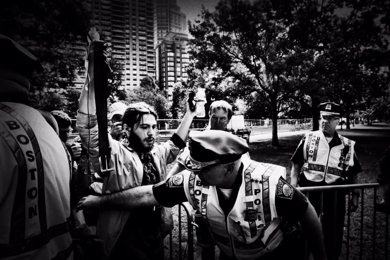 Image: Police officers perform security checks of attendees at the entrance of the demonstrations.