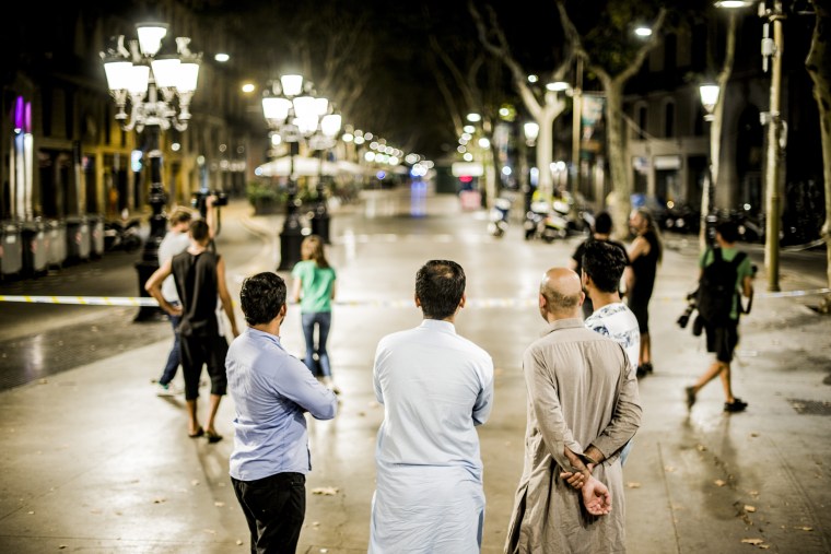 Image: Pakistani Muslim men watch as police work at the scene of a terrorist attack in Barcelona, Aug. 17, 2017.