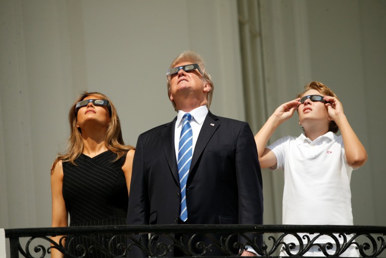 Image: U.S. President Trump watches the solar eclipse with first Lady Melania Trump and son Barron from the Truman Balcony at the White House in Washington