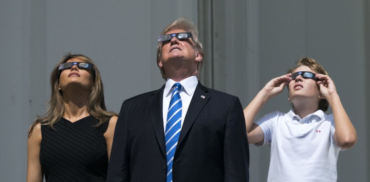 Image: President Donald Trump, First Lady Melania Trump, and Barron Trump view the solar eclipse from a balcony of the White House in Washington, DC, Aug. 21, 2017.