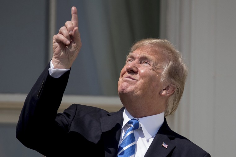 Image: President Donald Trump points to the sun as he arrives to view the solar eclipse, Aug. 21, 2017, at the White House in Washington.