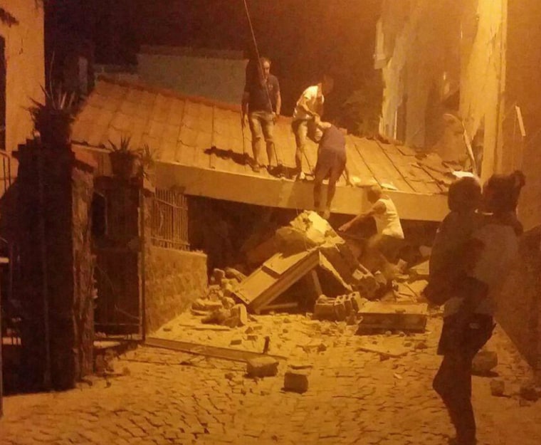 Image: People remove debris after an earthquake hit the island of Ischia, near Naples, Italy