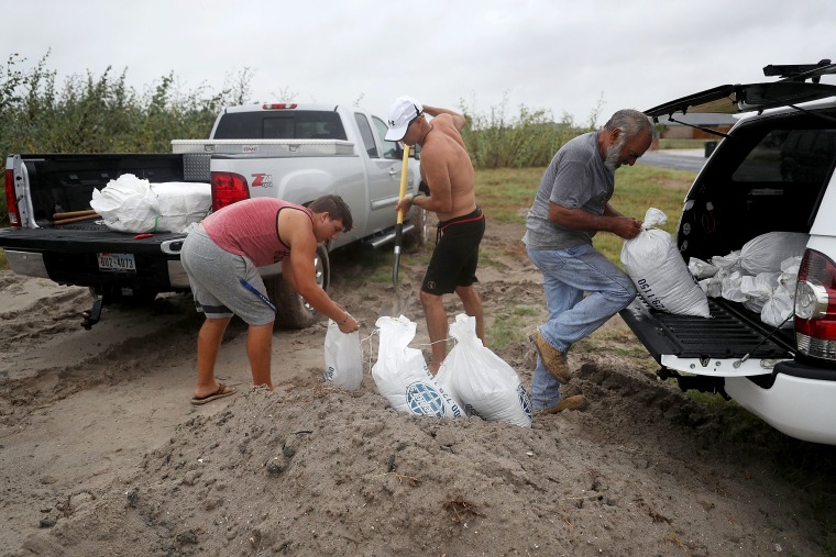 Image: Cody Munds, Lee Martin and John Pezzi, left to right, fill sandbags as people prepare for approaching Hurricane Harvey on Aug. 25, 2017 in Corpus Christi, Texas.