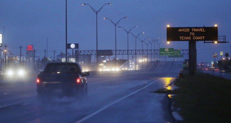 Image: Motorists pass a warning sign as Hurricane Harvey approaches the Gulf Coast area