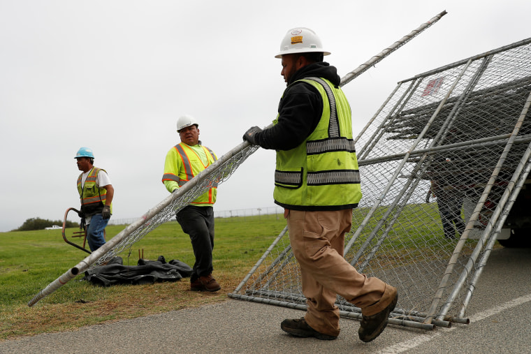 Image: Workers unload a chainlink fence at Crissy Field in anticipation of Saturday's Patriot Prayer rally and counter demonstration in San Francisco, California