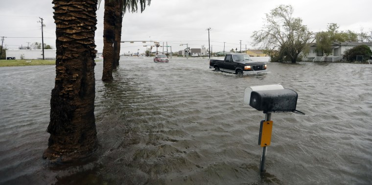 Image: A driver moves through flood waters left behind by Hurricane Harvey