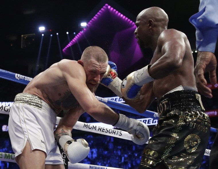 Floyd Mayweather Jr. hits Conor McGregor in a super welterweight boxing match Saturday, Aug. 26, 2017, in Las Vegas.