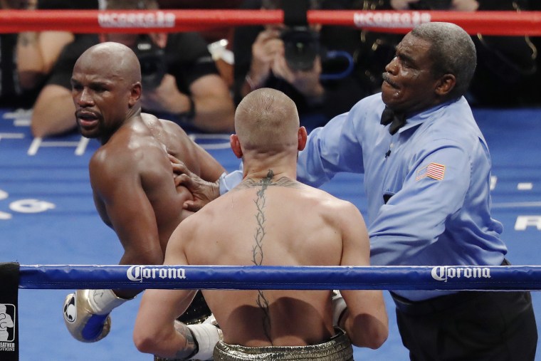Referee Robert Byrd, right, stops the fight between Floyd Mayweather Jr., left, and Conor McGregor in a super welterweight boxing match Saturday, Aug. 26, 2017, in Las Vegas.