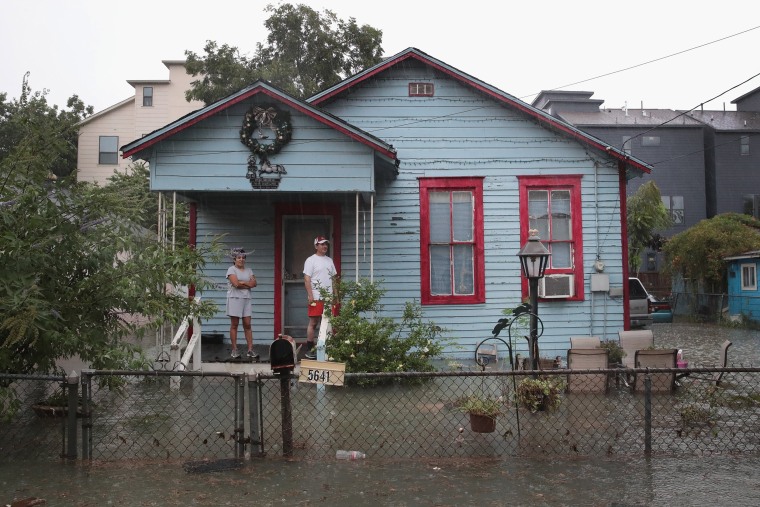 Image: Image: People on a porch watch as rain from Hurricane Harvey inundates the Cottage Grove neighborhood