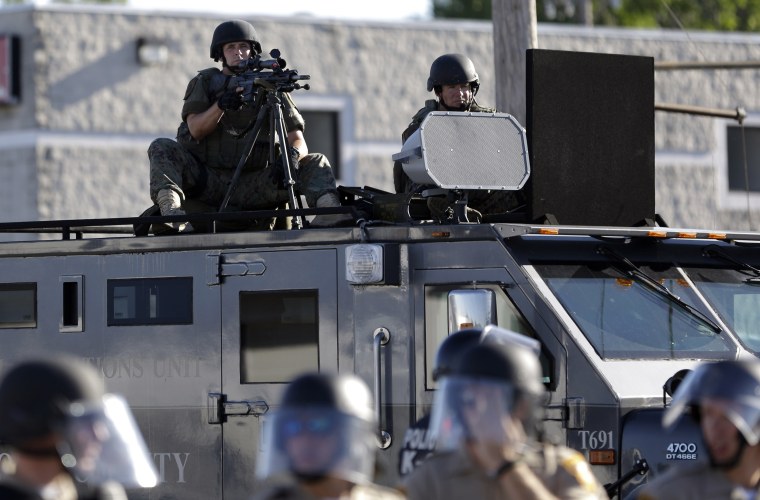 Image: A police tactical team moves in to disperse a group of protesters in Ferguson
