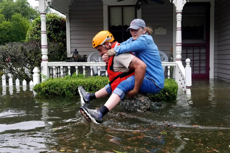 Image: A Texas National Guardsman carries a resident from her flooded home