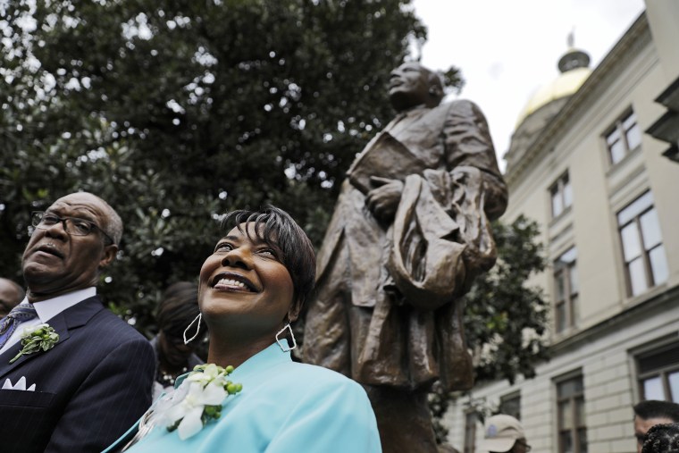Image: The Rev. Bernice King, right, daughter of the Rev. Martin Luther King Jr., stands under a statue paying tribute to her father